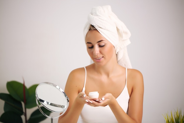 Beautiful girl applying cosmetic cream