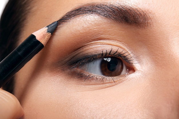 Beautiful girl applying cosmetics, closeup