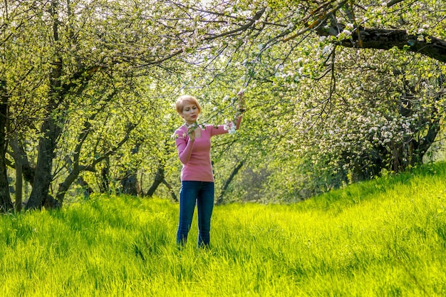 Bella ragazza tra le braccia di una bambina in un primo piano del parco in fiore