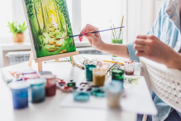 Beautiful girl artist paints on canvas at home