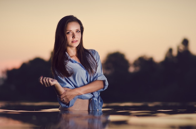 Beautiful girl bathing in the lake in a warm summer evening