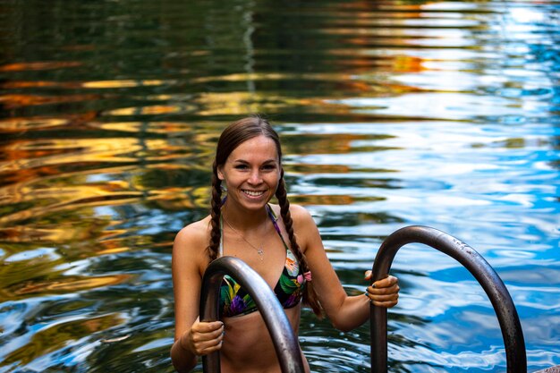 A beautiful girl in a bikini takes a refreshing dip in a rock pool under in karijini, australia