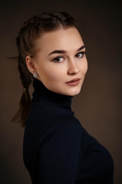 Beautiful girl in black clothes closeup photo on the background