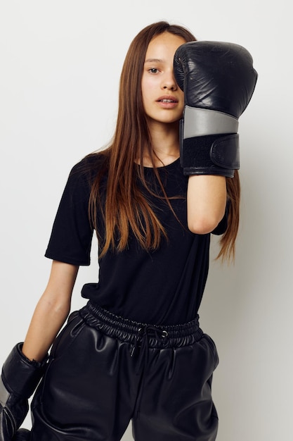 Beautiful girl in black sports uniform boxing gloves posing fitness training