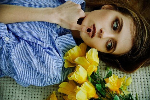 beautiful girl blonde with yellow flowers looking into the distance top view fashion shooting