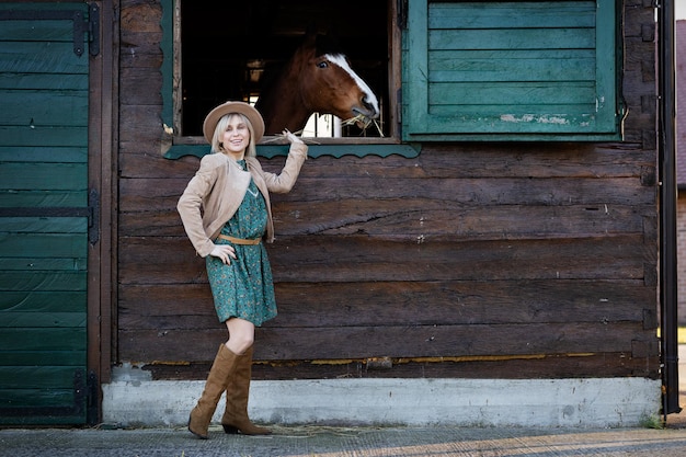 Красивая девушка в стиле бохо разговаривает с лошадью через окно