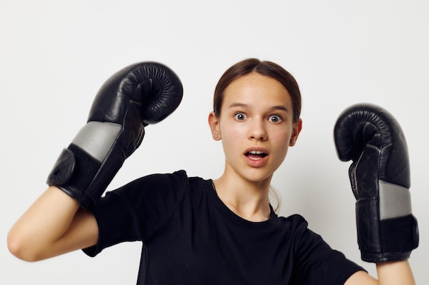 Beautiful girl in boxing gloves in black pants and a tshirt fitness training