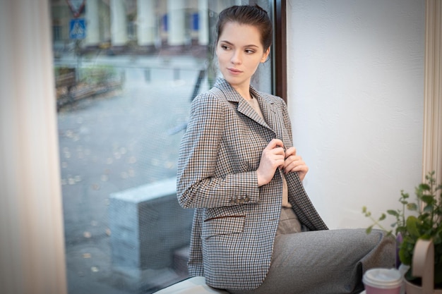 A beautiful girl in branded clothes against the background of a chic interior of the apartment