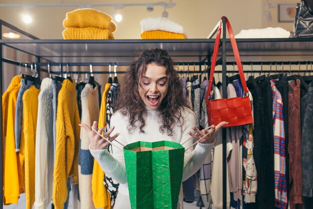 Beautiful girl buyer, trying on and buying beautiful stylish clothes in a boutique