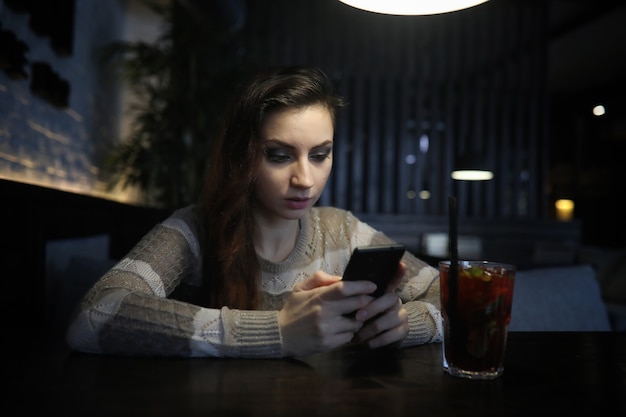 Beautiful girl in a cafe having a cup of coffee at a dinner