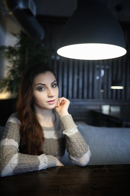 Beautiful girl in a cafe having a cup of coffee at a dinner