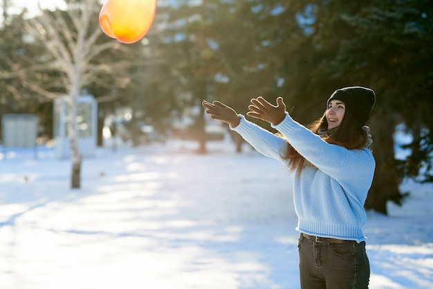 Photo beautiful girl catches a balloon in the shape of a heart, valentine's day