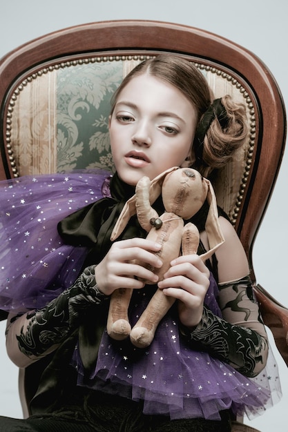 Красивая девочка-модель в модной одежде с игрушкой-кроликом