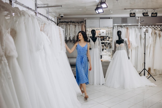 Foto la bella ragazza sceglie un abito da sposa nel salone di nozze