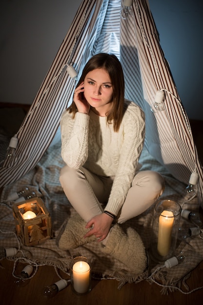 Beautiful girl on Christmas eve, sitting in a comfortable interior. New year.