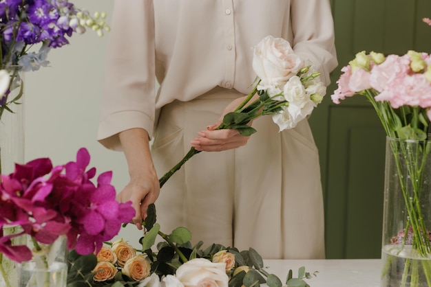 Beautiful girl collects a bouquet of flowers in a flower shop