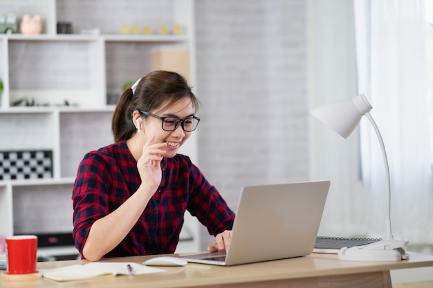 Bella riunione della conferenza della ragazza sul computer portatile, concetto domestico della forma di lavoro