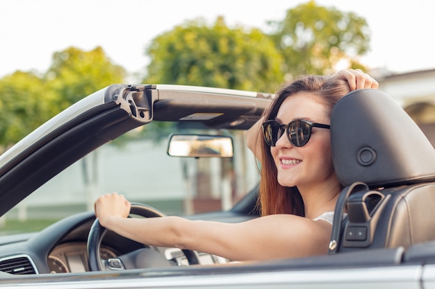 街で晴れた日にコンバーチブルカブリオ車で美しい少女