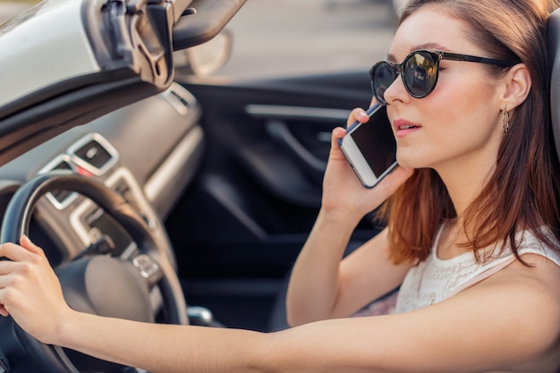 Beautiful girl in the  convertible cabrio car on a sunny day in a city