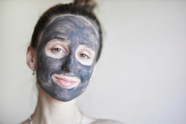 Beautiful girl in a cosmetic clay mask a young girl with a
cosmetic clay mask on her face