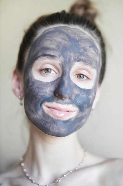 Beautiful girl in a cosmetic clay mask a young girl with a
cosmetic clay mask on her face