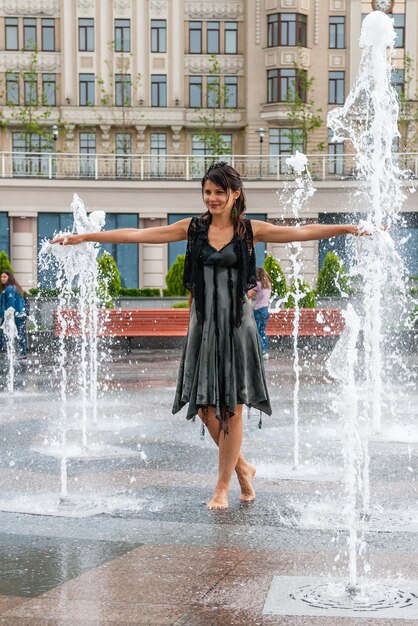 Beautiful girl dances in a fountain