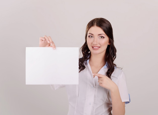 La bella ragazza il medico in un posto di lavoro