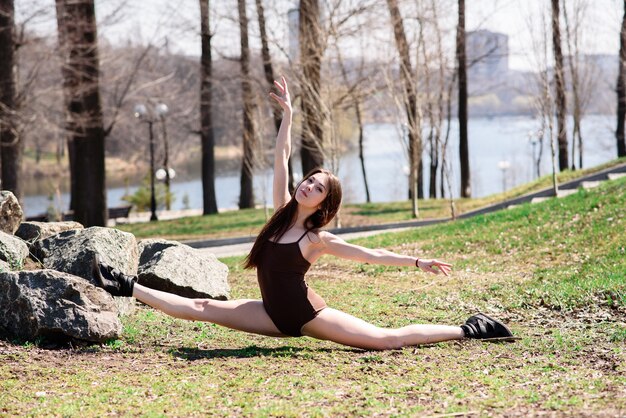 Beautiful girl doing stretching on nature.