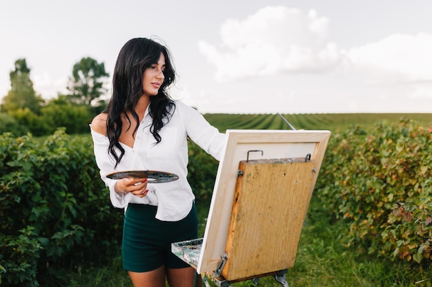 Beautiful girl drawing in the field