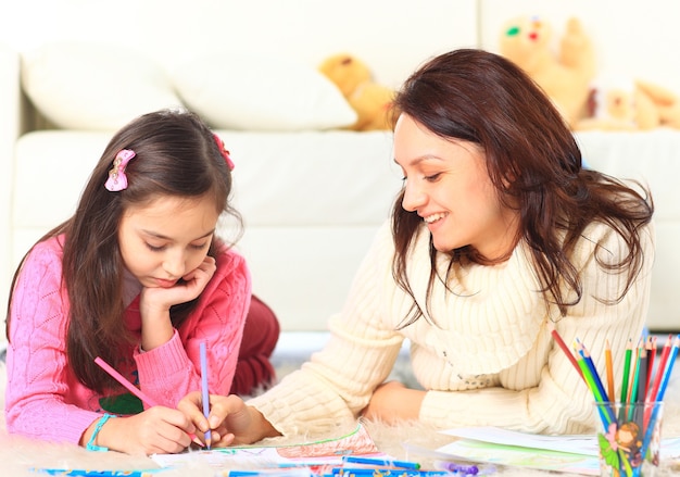 Beautiful girl draws with his mother