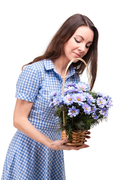 Beautiful girl in a dress in a blue cage with flowers chrysanthemums in hands on a white background