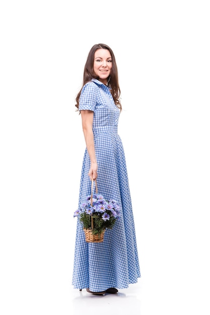 Beautiful girl in a dress in a blue cage with flowers chrysanthemums in hands on a white background