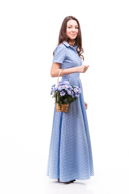 Beautiful girl in a dress in a blue cage with flowers chrysanthemums in hands on a white background