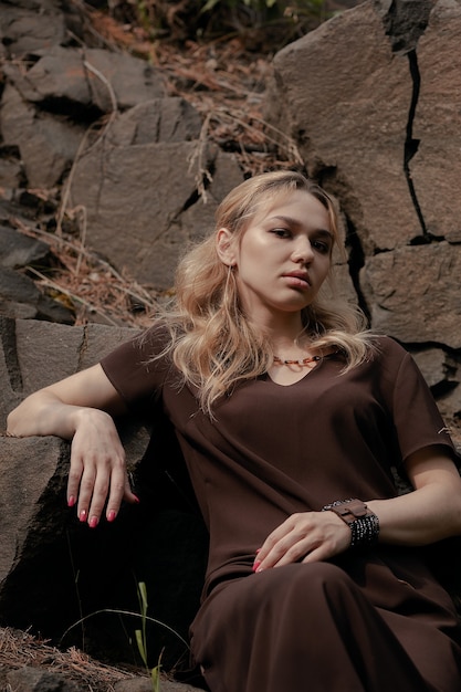 The Beautiful girl in a dress on the rocks