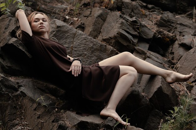 A Beautiful girl in a dress on the rocks