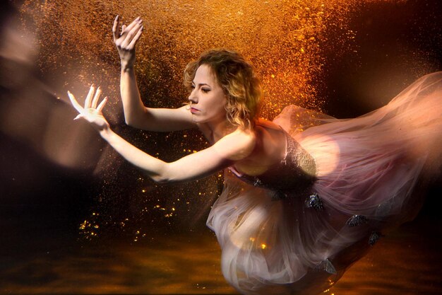 Foto bella ragazza in un vestito sott'acqua in uno studio fotografico