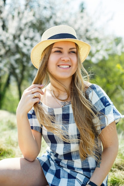 Beautiful girl in a dress walking in the spring forest where the trees bloom