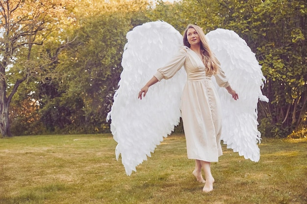 Beautiful girl dressed as an angel in the evening garden