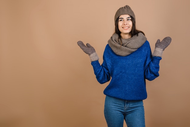 Beautiful girl dressed in a cute hat and gloves sincerely rejoices