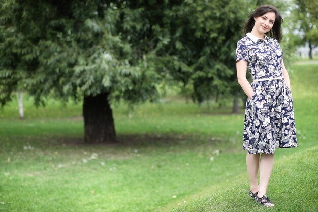 Beautiful girl in dresses for a walk in the park