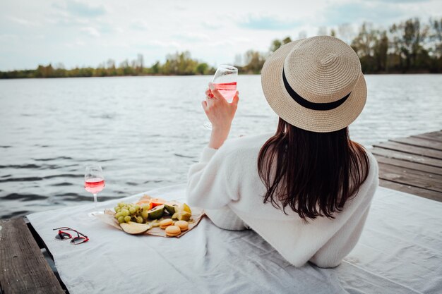 Photo beautiful girl drinking rose wine at the beach