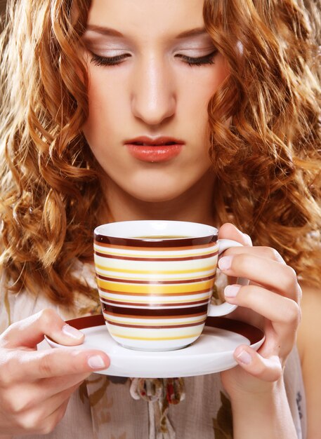 Bella ragazza che beve tè o caffè.