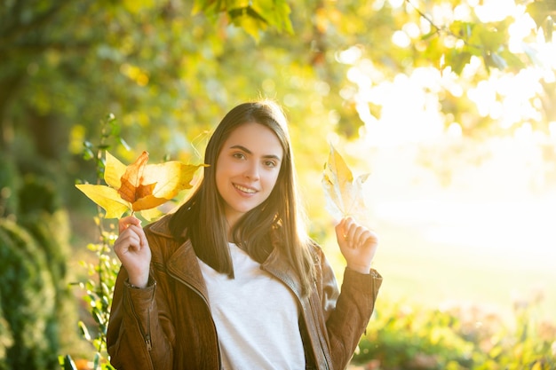 Beautiful girl enjoying autumn. Young woman and autumn weather.