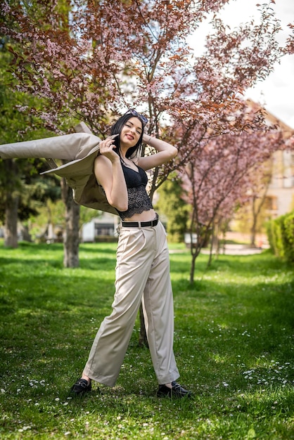 Beautiful girl enjoying nature stand in spring garden under blooming tree branches