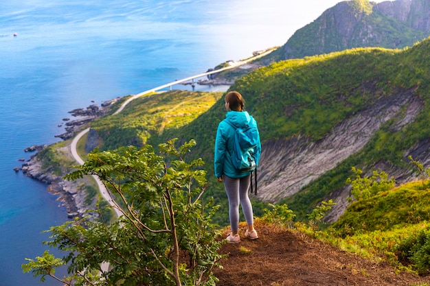 beautiful girl enjoys the panorama of lofoten islands in norway from the famous reinebringen summit