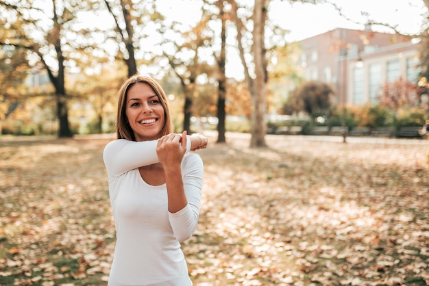 Beautiful girl exercising in autumn park.