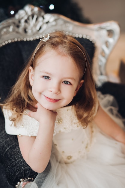 Beautiful girl in festive dress and small crown.