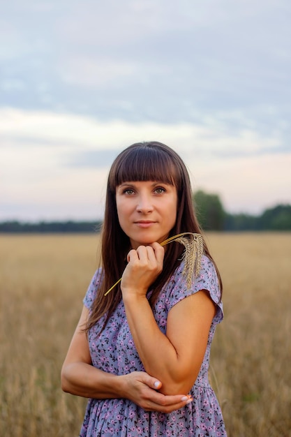 Photo a beautiful girl in a field with wheat milk and bread peacetime happiness love