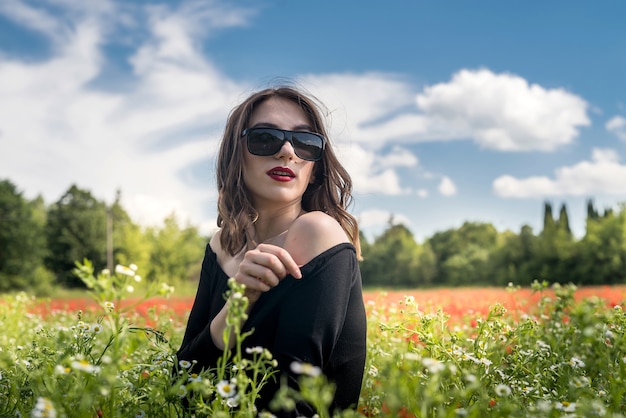 Beautiful girl on the flowers field, sunny day. Summer time