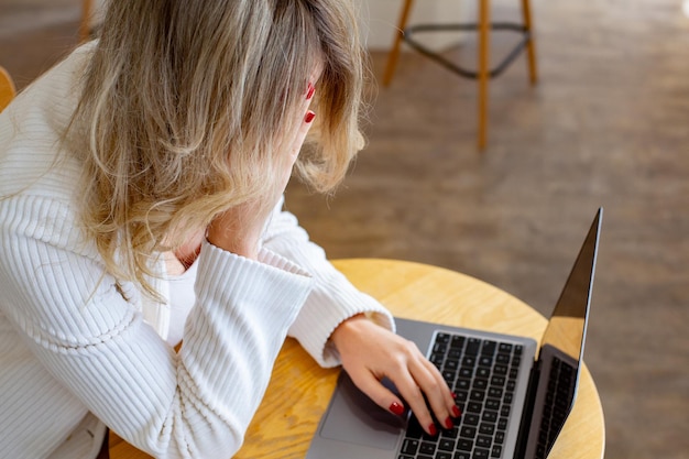 Beautiful girl freelancer feeling tired and stressed while using a laptop and working remotely.